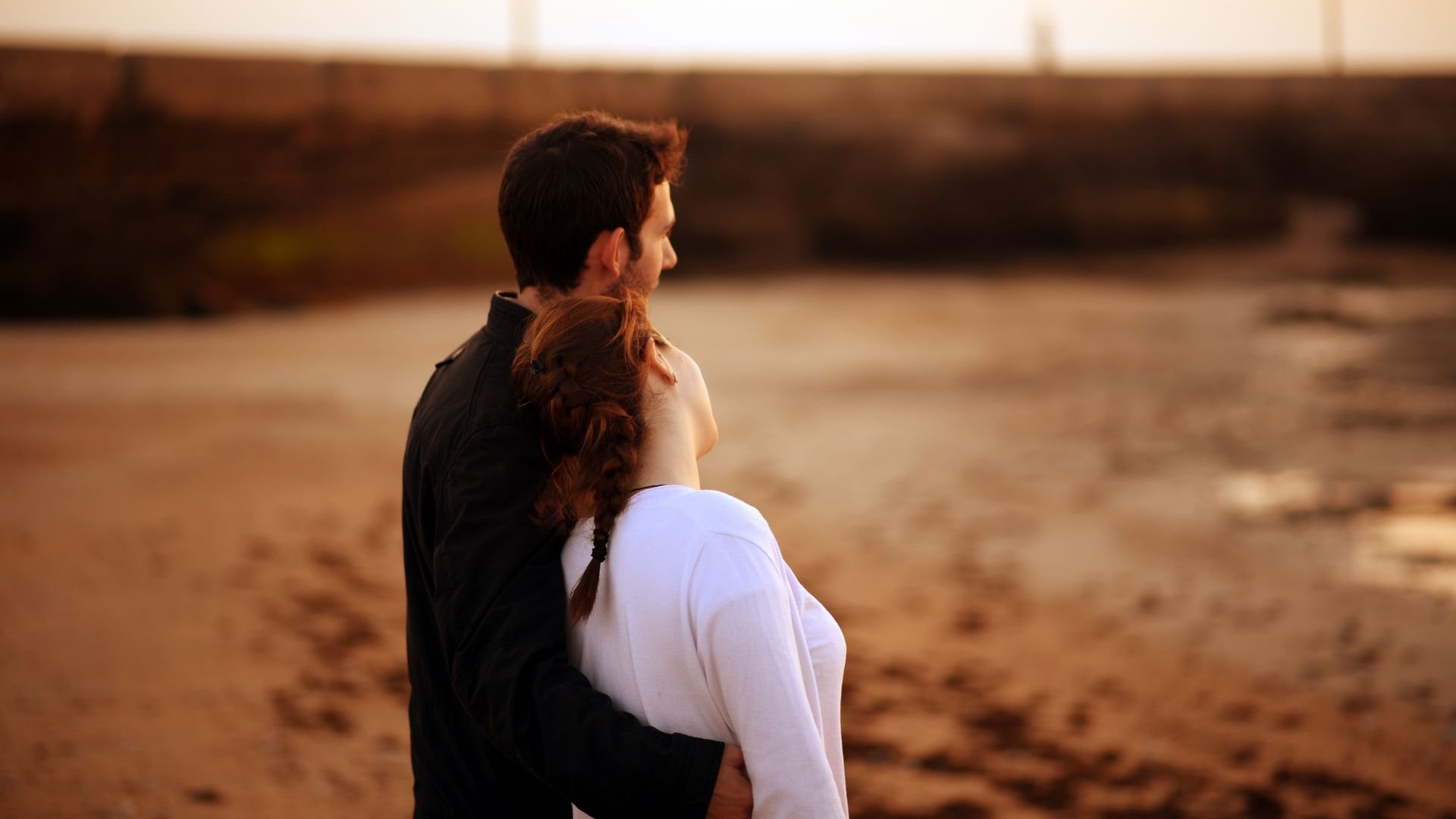 couple hugging while watching the ocean